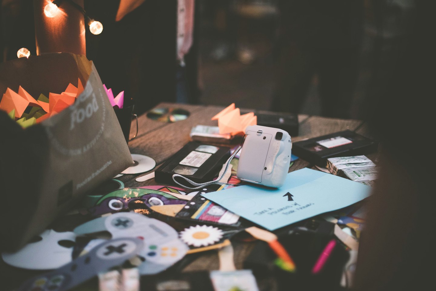 Rustic table with party supplies and instant camera.
