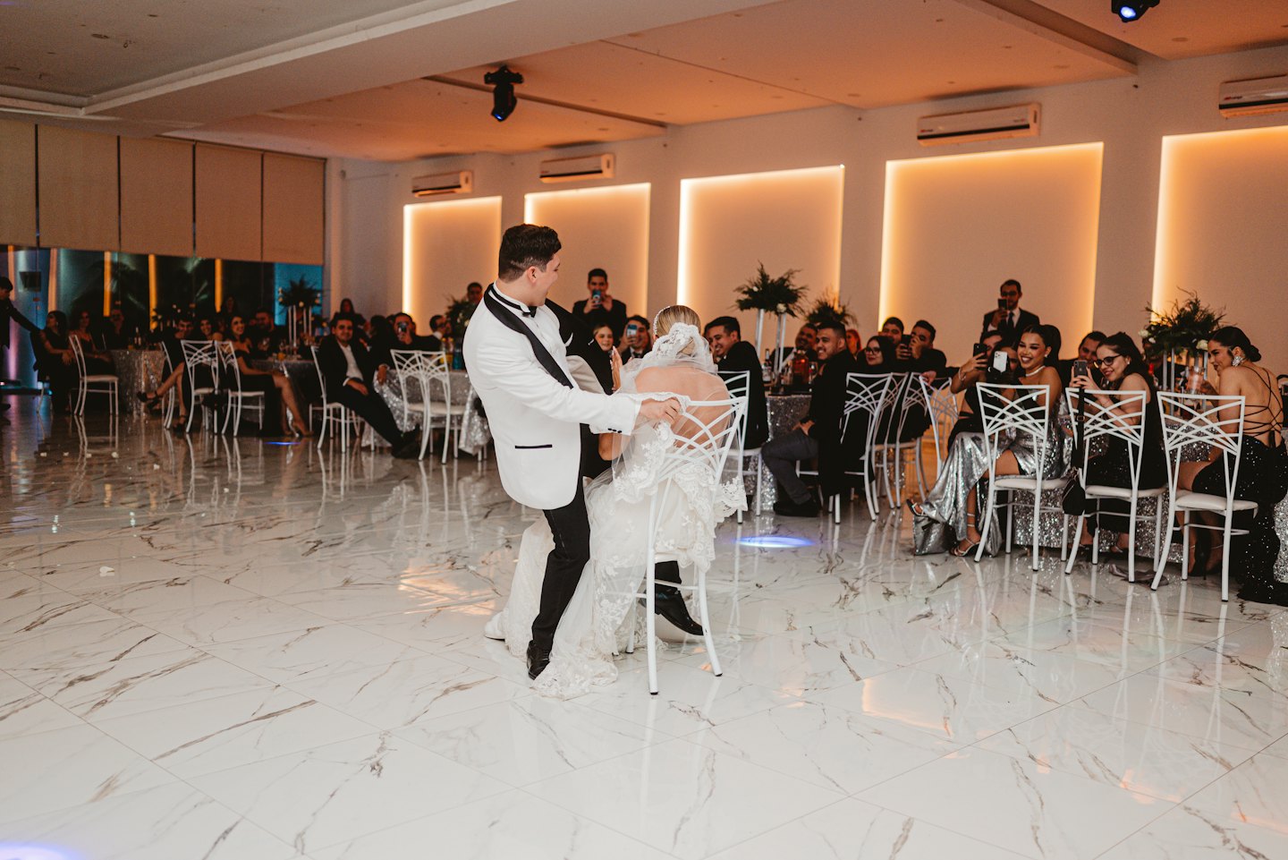 A groom removes a garter from his bride at their wedding.