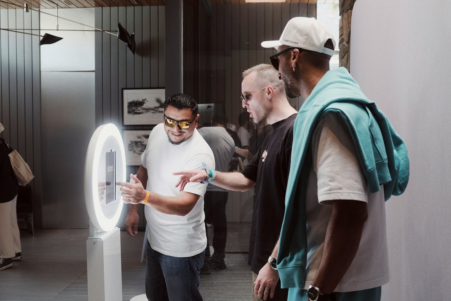 Men interacting with a digital photo booth with a ring light.